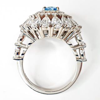 טבעת קוקטייל יהלום אובל כחול משובצת יהלומי מעבדה 6.70 קראט | מתועדת IGI | זהב לבן 14 קראט 9.23 גרם End Date: 21/02/2026